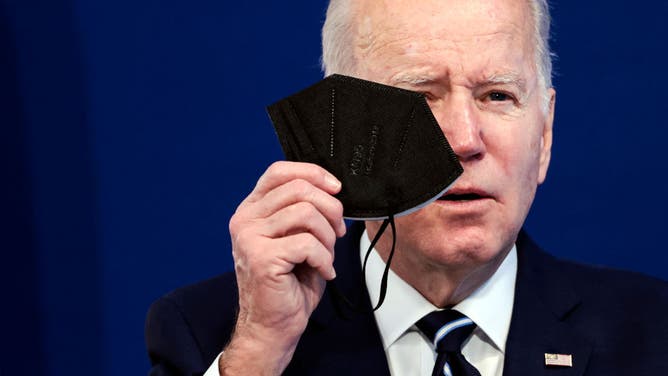 Joe Biden holding a COVID-19 mask