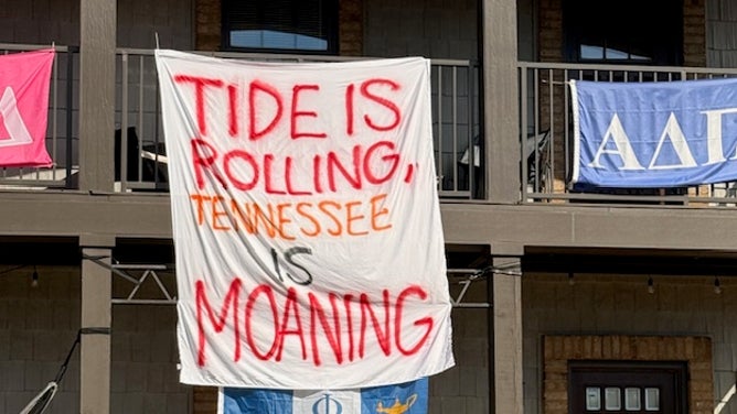Alabama students hang signs outside their houses before the Tennessee game on Saturday night.