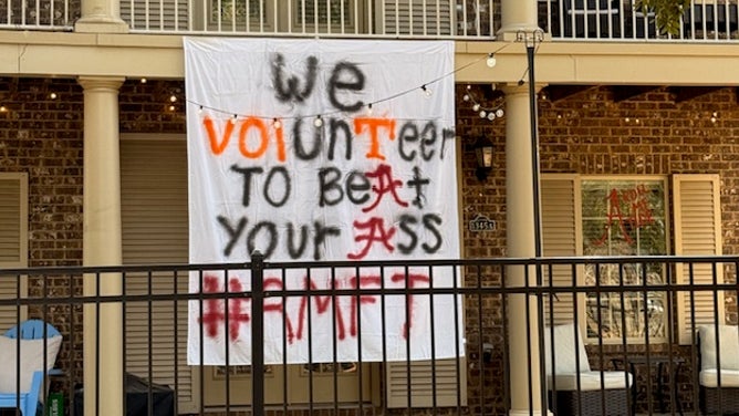Alabama students hang signs outside their houses before the Tennessee game on Saturday night.