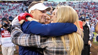 Hugh Freeze hugging his daughters on the field at Auburn