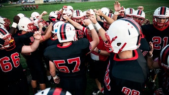 High school football players in a pregame huddle