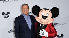 Disney CEO Bob Iger standing with Mickey Mouse