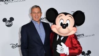 Disney CEO Bob Iger standing with Mickey Mouse