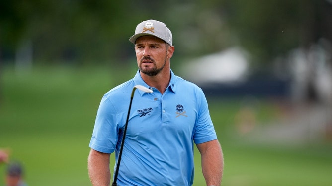 Bryson DeChambeau holding an iron