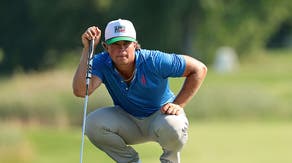 Michael La Sasso reading a putt on the green