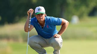 Michael La Sasso reading a putt on the green