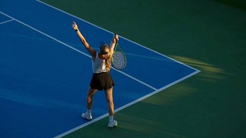 A female tennis player hitting a serve