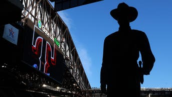 The "One Riot, One Ranger" statue is silhouetted by the sky visible from the open roof of Globe Life Field before a game between the Texas Rangers and Seattle Mariners at Globe Life Field on April 06, 2026.