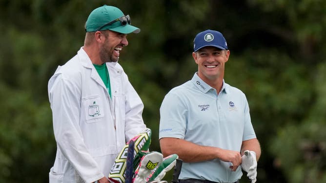 Bryson DeChambeau laughs with his caddie, Greg Bodine, on the 15th hole during a practice round for the Masters Tournament at Augusta National Golf Club.